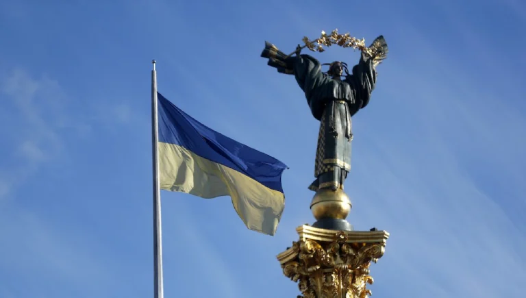 (FILE). A national flag waves in front of the Independence monument in the central square of Kiev, Ukraine. Photo: EFE.