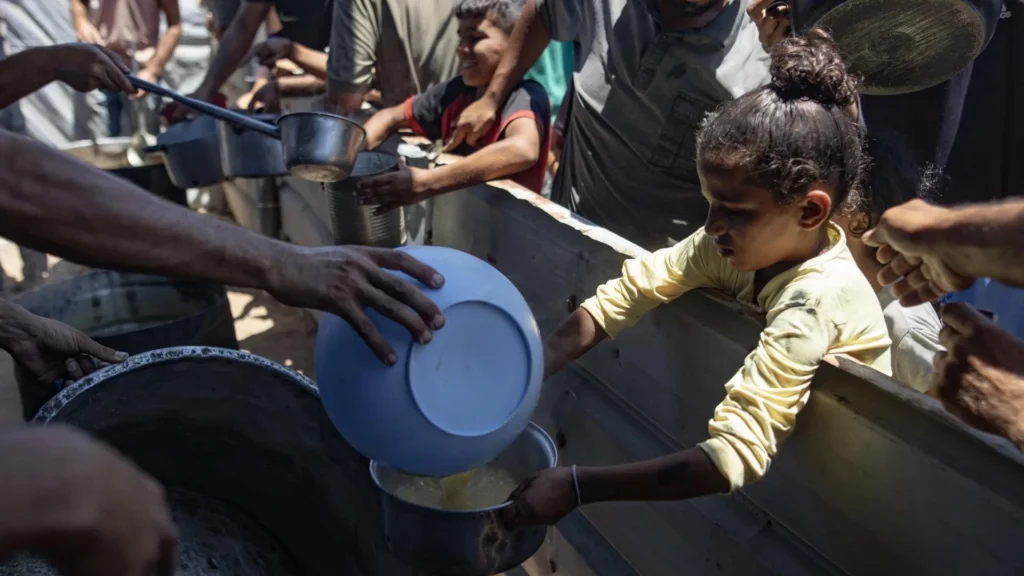 (FILE) Internally displaced Palestinians gather outside a charity kitchen to receive limited food rations amid the lack of food availability, in Gaza City, 19 July 2025. Photo: EFE.