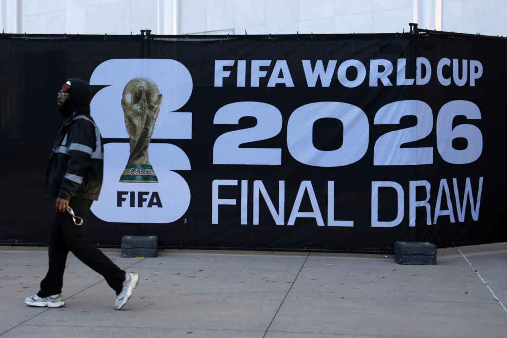 A volunteer walks past a sign reading 'FIFA World Cup 2026 Final Draw' displayed outside of the Kennedy Center ahead of the FIFA 2026 World Cup Draw in Washington, DC, USA, 04 December 2025. The draw is scheduled for 05 December, when 64 nations will be drawn into groups for next year's FIFA World Cup. Photo: EFE