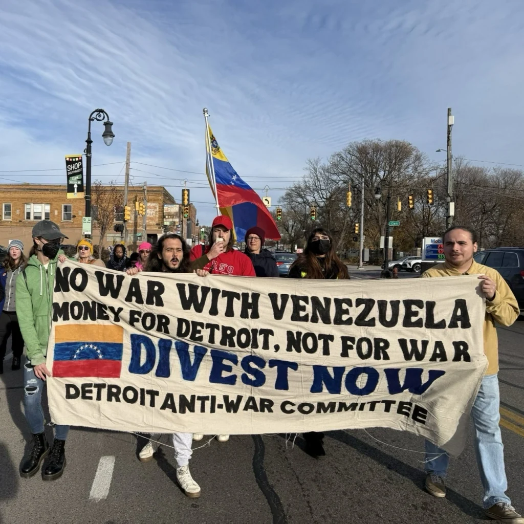 Protesters march in a US city holding signs against the US war against Venezuela.
