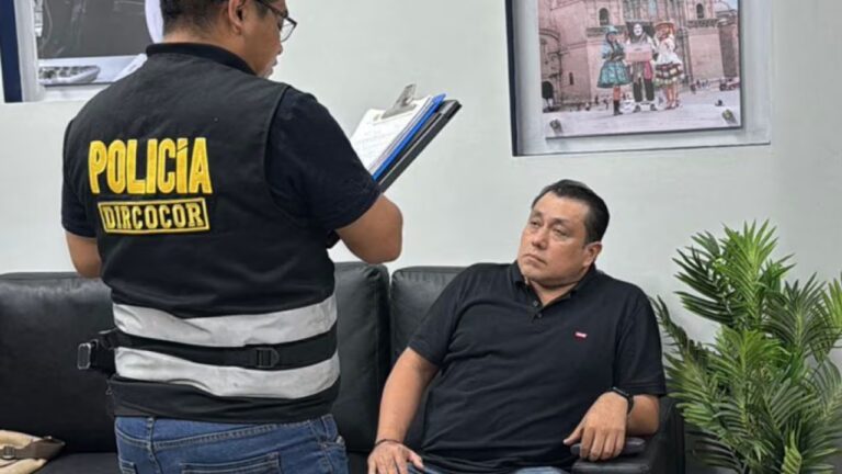 This photograph, distributed by the National Police of Peru, shows the arrest of José Edilberto Samame Blas, director of electoral management of the National Office of Electoral Processes by an anti-corruption police officer in Lima. Photo: AFP.