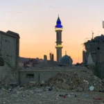 A lit mosque between two buildings destroyed by war in Nabatieh, southern Lebanon. Photo: EFE.