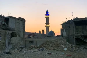 A lit mosque between two buildings destroyed by war in Nabatieh, southern Lebanon. Photo: EFE.