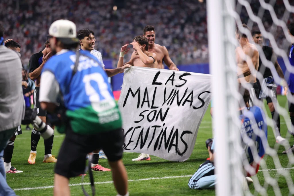 Argentine players holding up a banner that reads "Malvinas are Argentine". Photo: TRT World.
